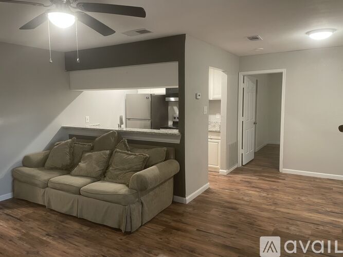 A living room with a couch and a ceiling fan.