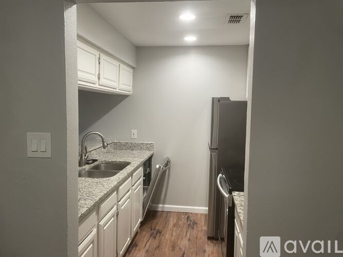 A kitchen with white cabinets and a granite countertop.