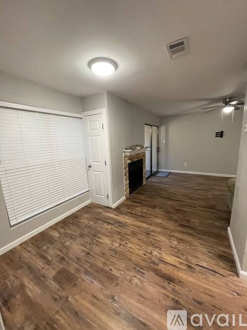 A room with wooden flooring and a white door.