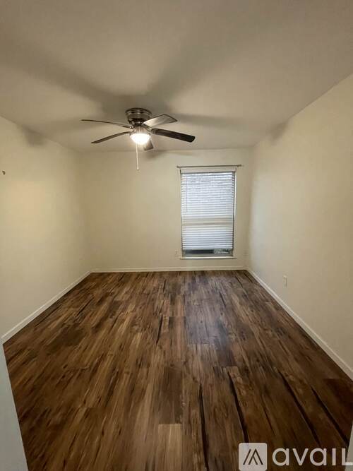 A room with wooden flooring and a ceiling fan.
