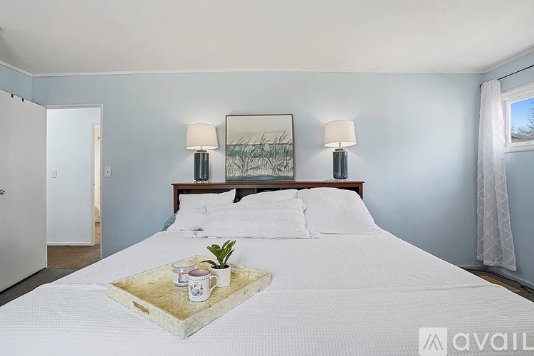 A bedroom with a large bed and a tray with a plant and candles on it.