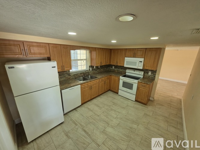 A kitchen with wooden cabinets and a white refrigerator.