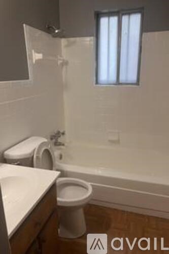 A white toilet sits next to a bathtub in a bathroom.
