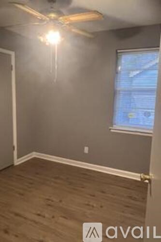 A room with a ceiling fan and a window.