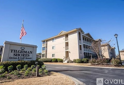 A sign for Tilghman Shores Ocean & Golf Resort stands in front of a building.