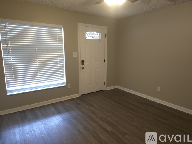 A room with a white door and a window with blinds.