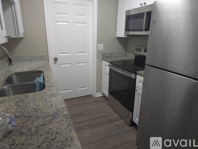 A kitchen with a sink, stove, and refrigerator.
