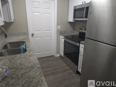 A kitchen with a sink, stove, and refrigerator.