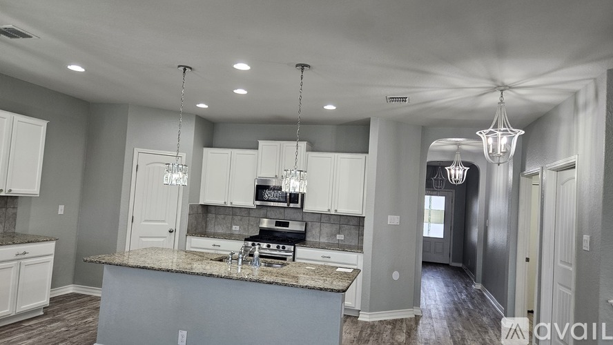 A kitchen with a granite countertop and a stove top oven.