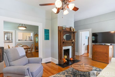 A living room with a grey couch and a fireplace.