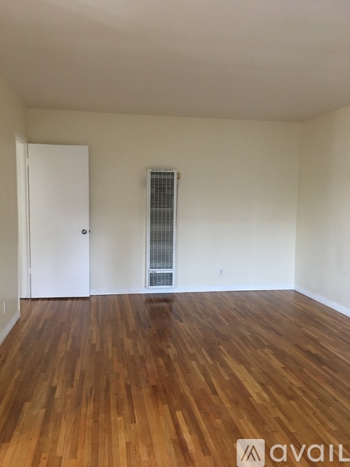 A room with wooden floors and a white door.