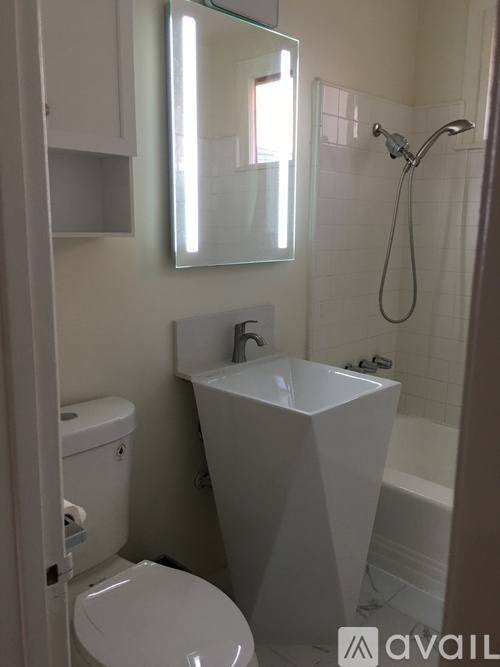 A white toilet sits next to a white sink in a bathroom.