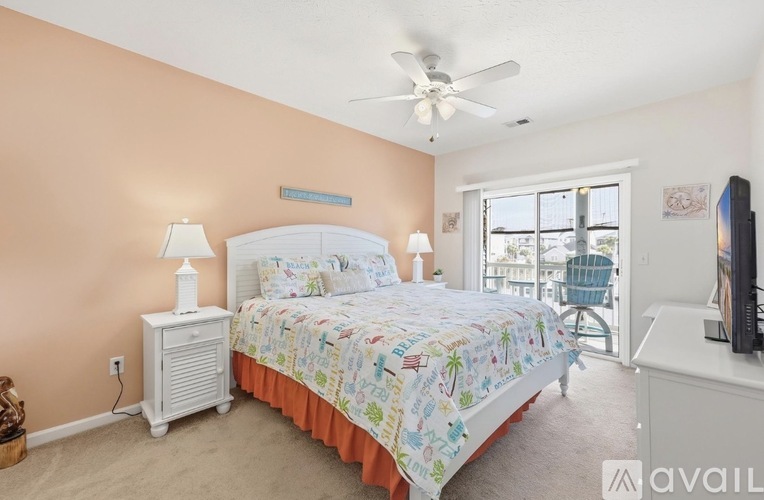 A bedroom with a bed, a ceiling fan, and a television.