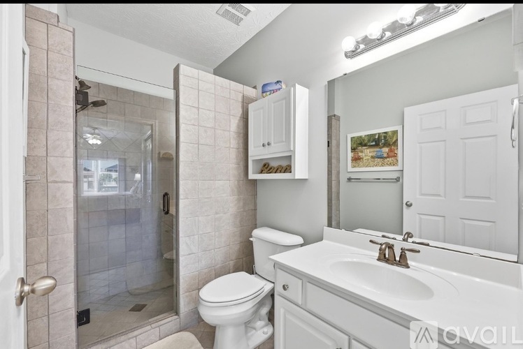 A bathroom with a toilet, sink, and shower.