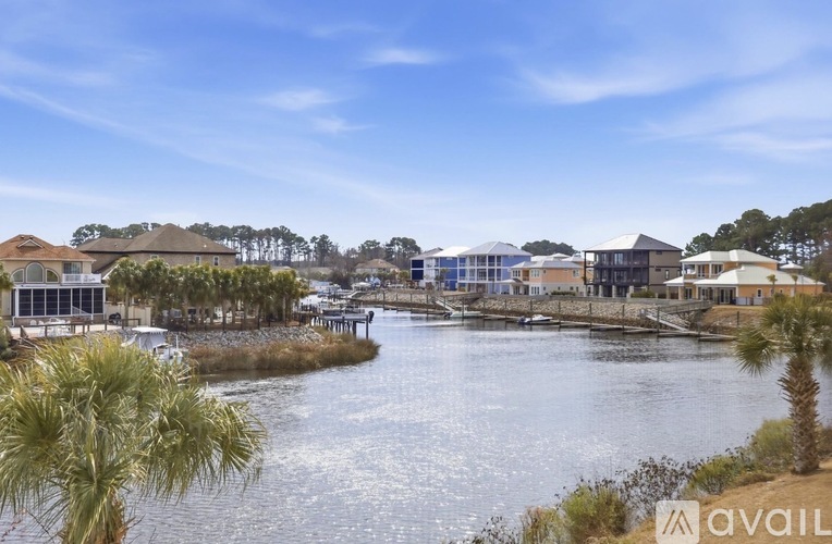 A view of a waterfront with houses and palm trees.
