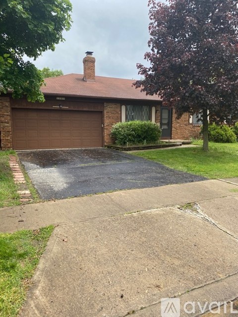 A house with a brown garage door and a brick wall.