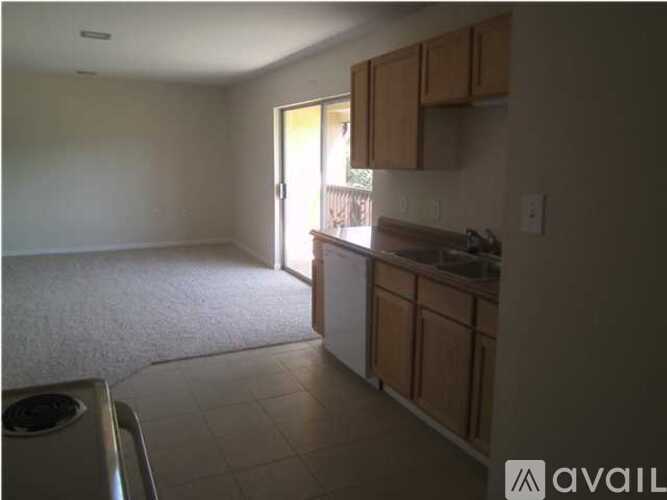 A kitchen area with wooden cabinets and a white washing machine.