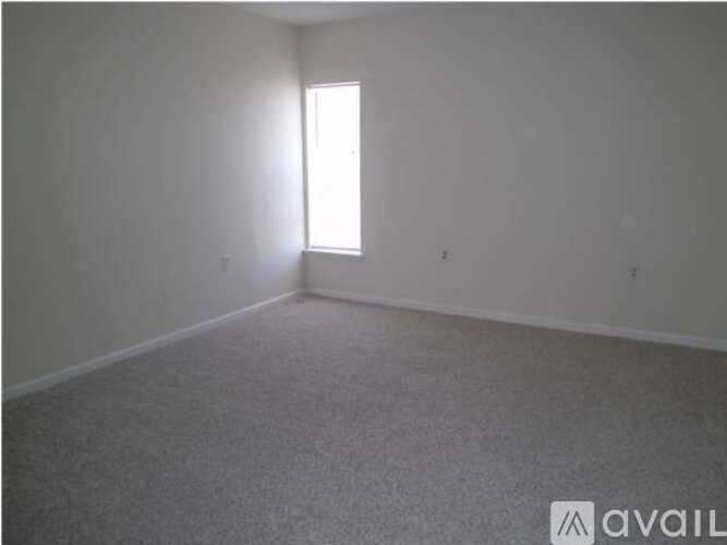 A room with a window and carpeted floor.