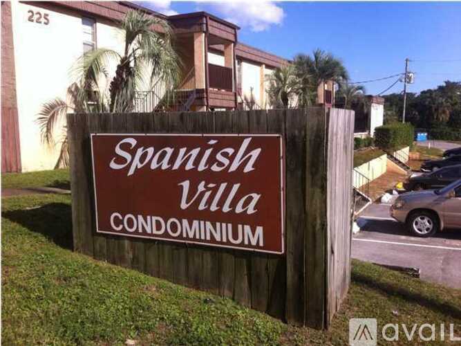 A sign for the Spanish Villa Condominium stands in front of a building.