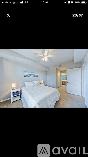 A bedroom with a bed, nightstand, and a ceiling fan.