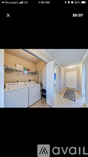 A kitchen with white appliances and a laundry area with a washer and dryer.