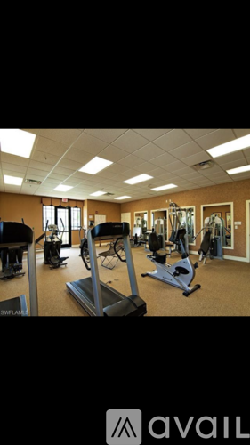 A gym with a variety of equipment including treadmills, weights, and exercise machines.