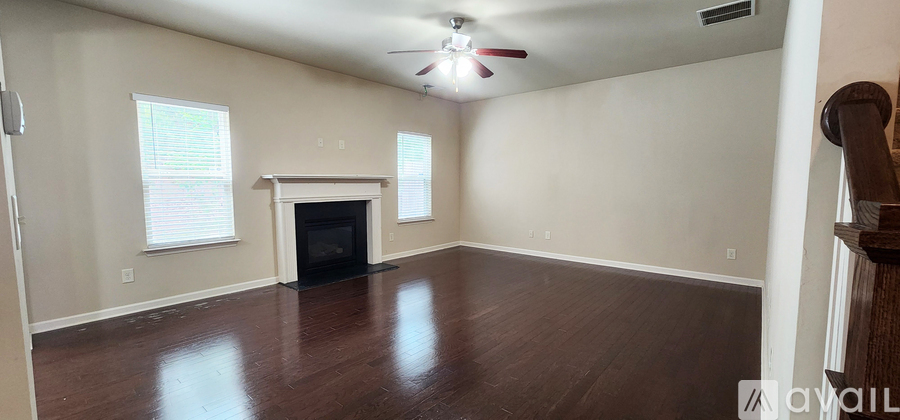 A spacious living room with a fireplace and wood flooring.