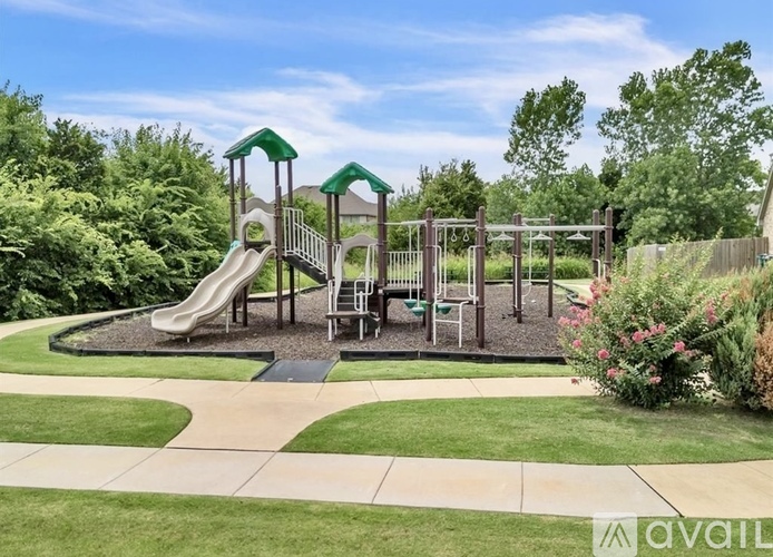 A playground with a slide, swings, and a green canopy.