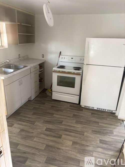 A kitchen with a white refrigerator, white cabinets, and a white oven.