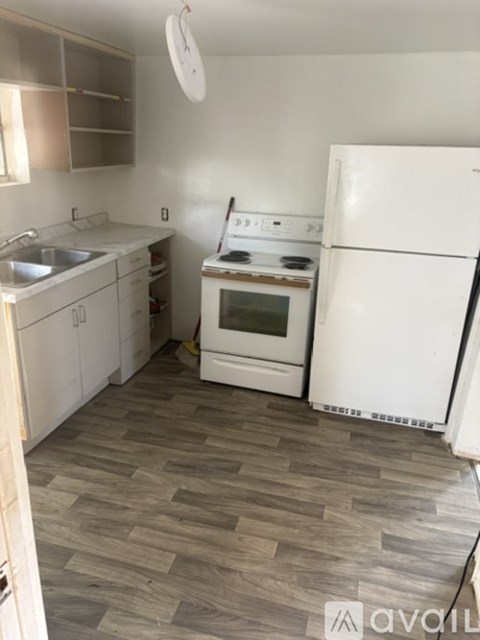 A kitchen with a white refrigerator, white cabinets, and a white oven.