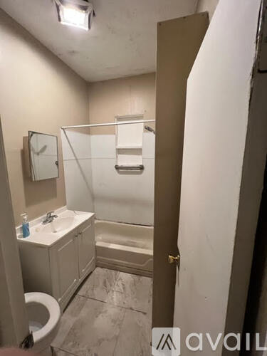 A bathroom with a toilet, sink, and bathtub.
