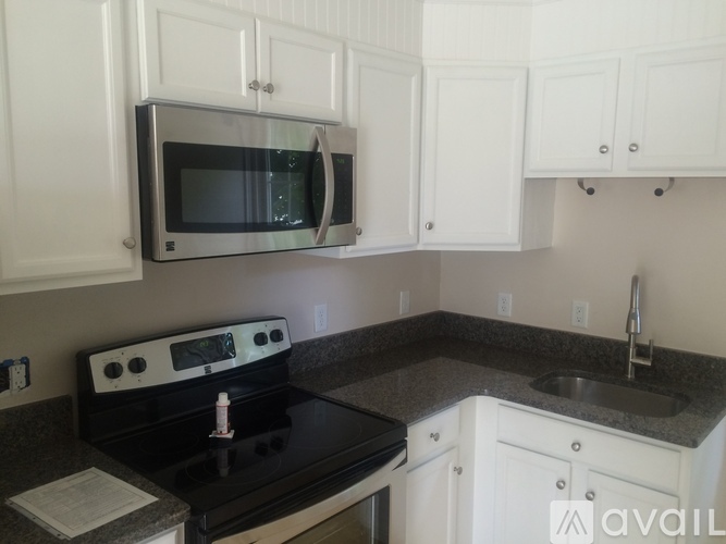 A kitchen with white cabinets and a black stove top.