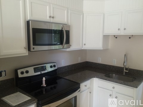 A kitchen with white cabinets and a black stove top.