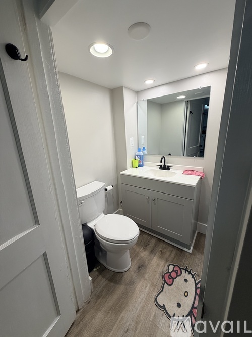 A small bathroom with a toilet, sink, and a mirror.