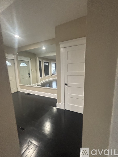 A hallway with black flooring and white doors.