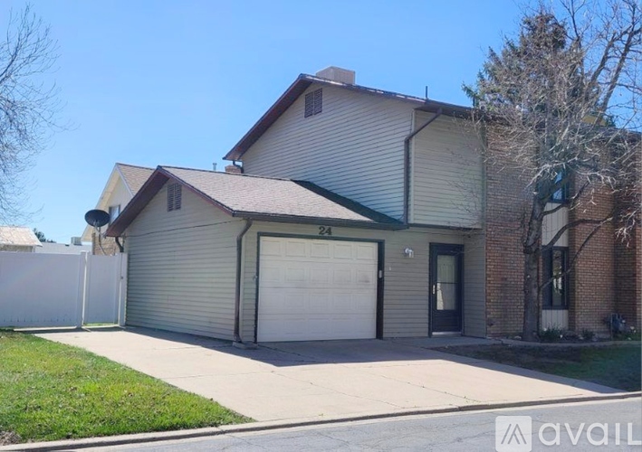 A house with a garage and a driveway in front.