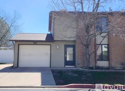 A house with a white garage door and a black door.