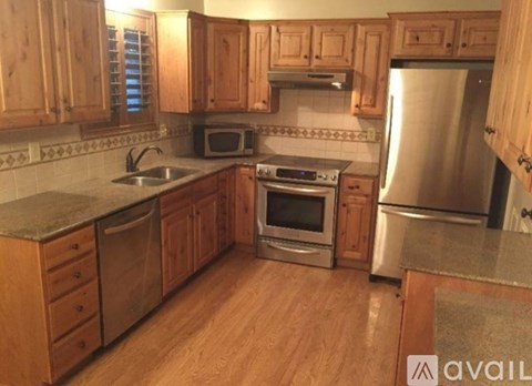A kitchen with wooden cabinets and stainless steel appliances.