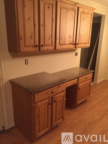 A kitchen with wooden cabinets and a granite countertop.