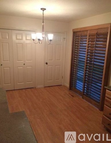 A room with wooden floors and a chandelier.