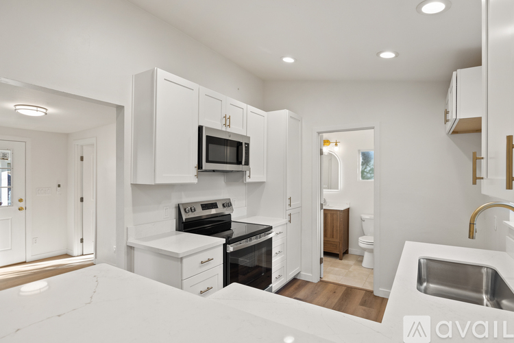 A modern kitchen with white cabinets and appliances.