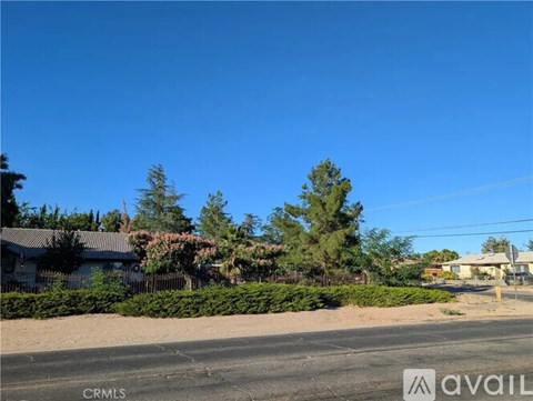 A street view with houses and trees on both sides.