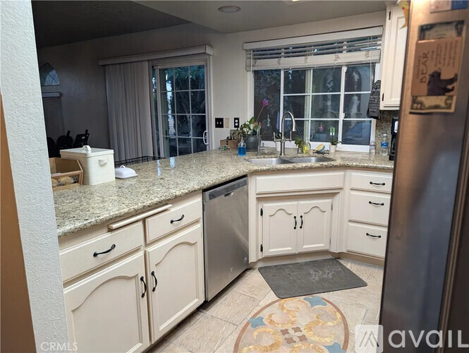 A kitchen with white cabinets and a granite countertop.