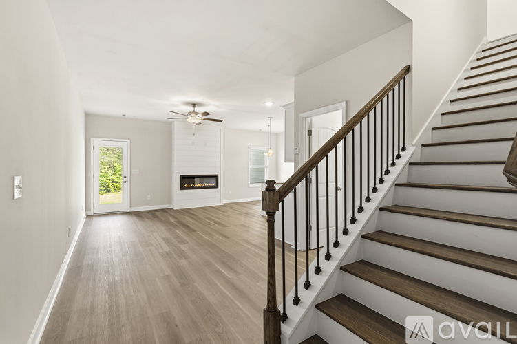 A spacious living room with a staircase leading to the upper floor.
