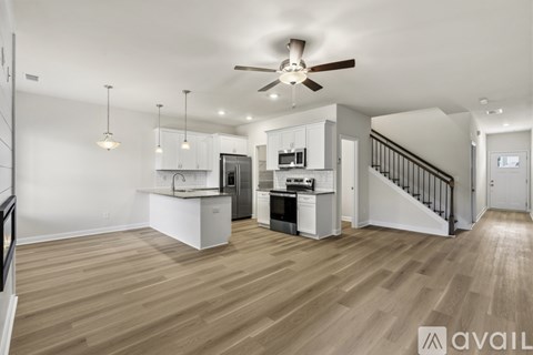 A spacious kitchen with a stove top oven and a refrigerator.