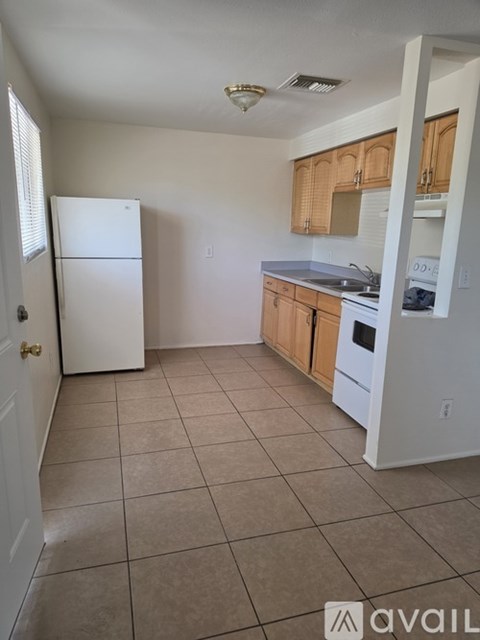 A kitchen with white appliances and wooden cabinets.