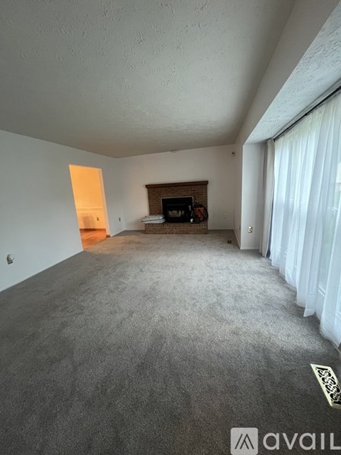 A living room with a grey carpet and a flat screen TV.