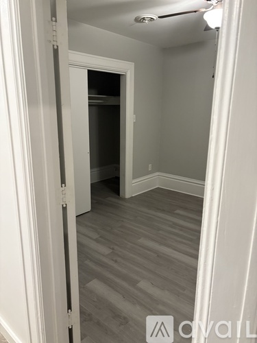 A hallway with a door at the end and a logo on the bottom right.