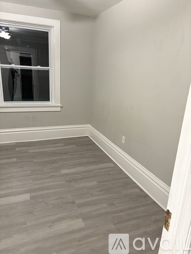 A room with a grey floor and a window.