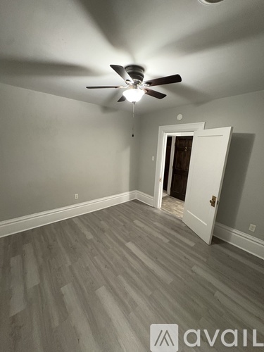 A room with a ceiling fan and a door.